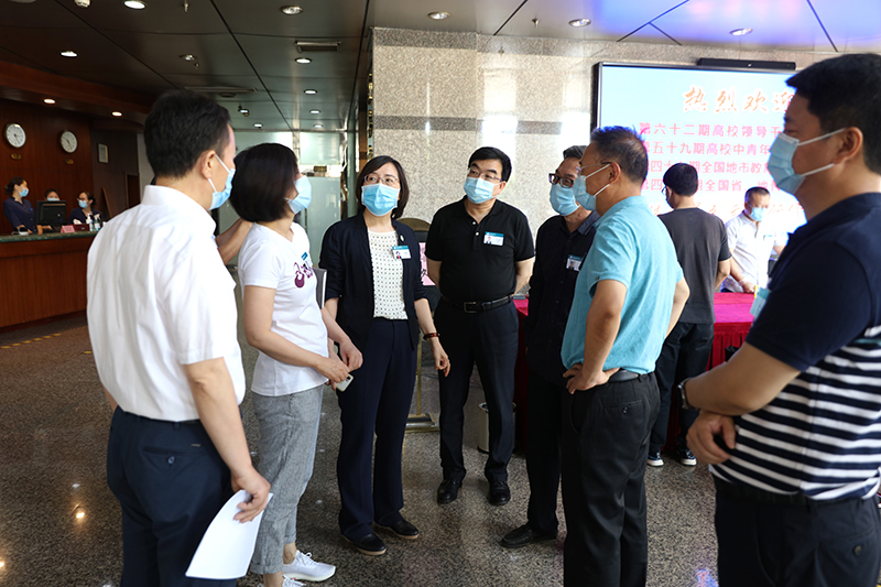 在校长大厦报到前台，“学员”正按照一米的间隔有序排队办理报到手续。跟随着两位已经办好报到手续的“学员”，学院领导一行前往两位“学员”入住的1401和1410房间进行了查看。另外，在学员教室、研讨室、学员餐厅、图书角、逸夫楼等地方，大家详细巡查，并针对教室里“学员”发热不适这一突然情况进行了紧急处置演练。